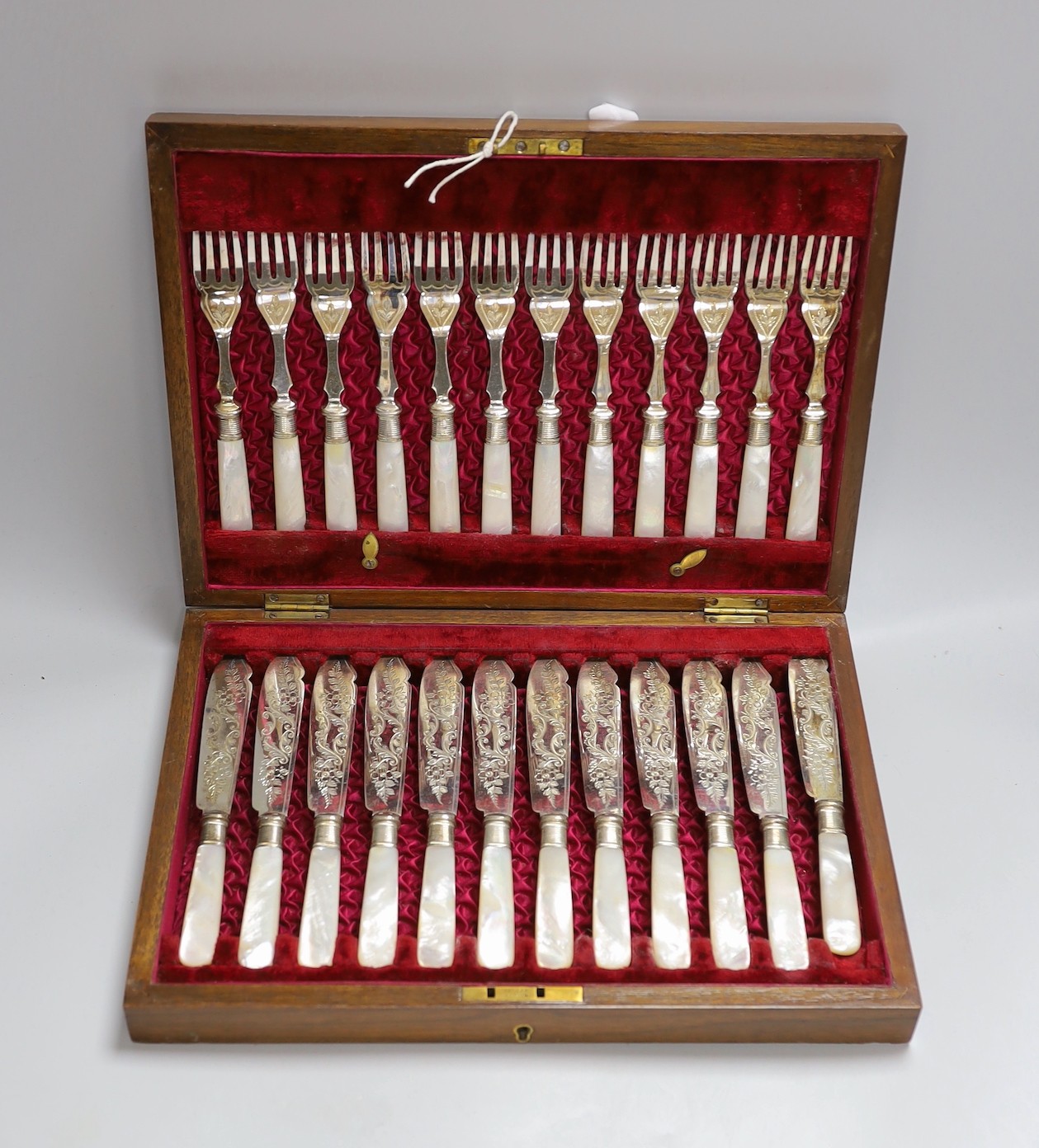 Twelve pairs of silver plated fish knives and forks with mother of pearl handles, in wooden canteen